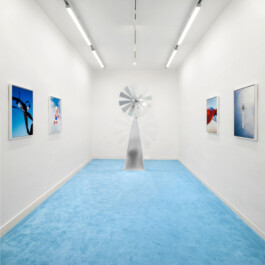 Oliviero Fiorenzi, Otto Cieli, Installation view with a series of photos and a wind turbine blade-shaped aluminum sculpture at The Address, Brescia, 2022 Installation view of last exhibition at the gallery